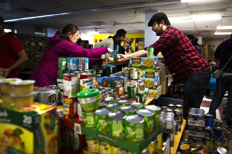 Volunteers sort food donations intended for distribution to the public Sunday as surrounding neighborhoods remain without power from damage caused by Sandy in Hoboken, N.J.

