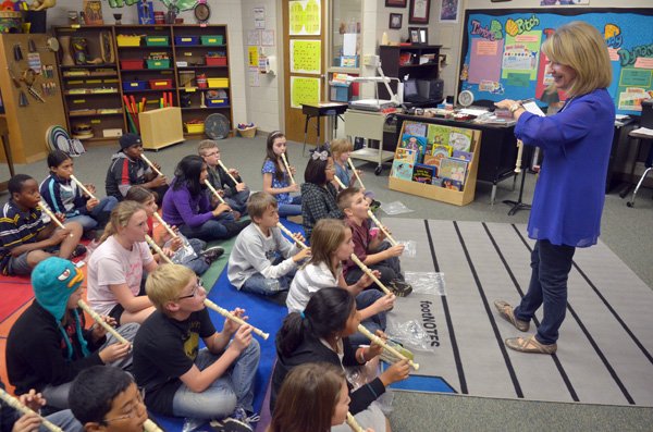 Carlena Lambert works with music students Friday afternoon at Asbell Elementary School in Fayetteville. Lambert is the longest-serving teacher at Asbell. The school celebrates its 50th anniversary Thursday. 