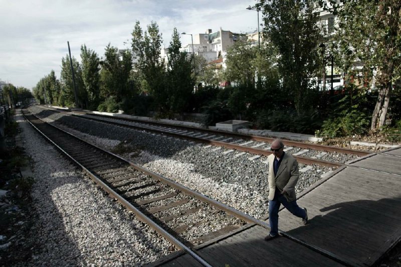 A man crosses railroad tracks Monday during a 24-hour strike in Athens, Greece. Three days of anti-austerity strikes, including hospital doctors, taxi drivers and transport workers, started Monday in Greece. 