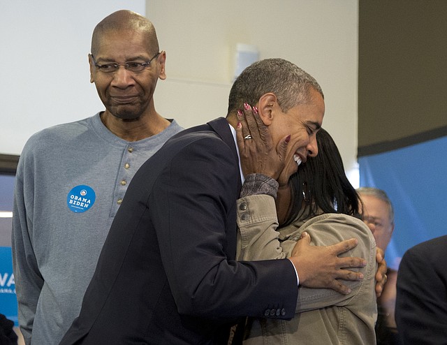 President Barack Obama is embraced by a volunteer as he visits a campaign office the morning of the 2012 election, Tuesday, Nov. 6, 2012, in Chicago.
