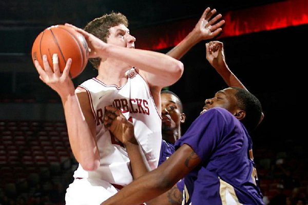 Arkansas sophomore Hunter Mickelson shoots over LeMoyne-Owen’s Edwin Shorter during the first half of Monday’s exhibition game. Mickelson had nine points and the Razorbacks won 111-45.
