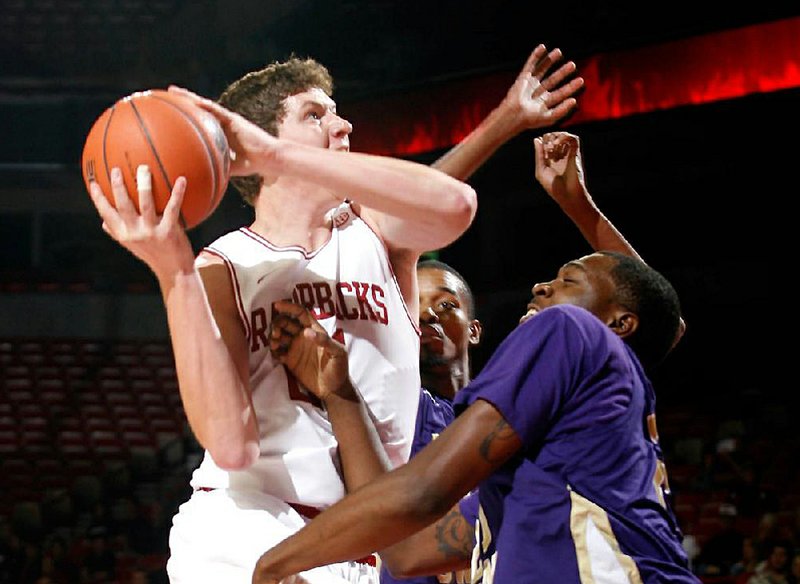 Arkansas sophomore Hunter Mickelson shoots over LeMoyne-Owen’s Edwin Shorter during the first half of Monday’s exhibition game. Mickelson had nine points and the Razorbacks won 111-45. 