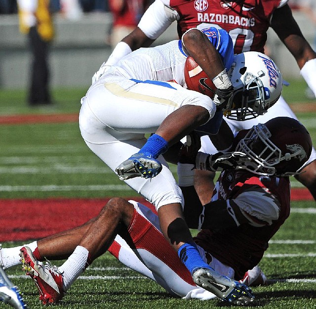 Arkansas’ Demetrius Wilson (right) pulls down Tulsa’s Trey Watts during Arkansas’ 19-15 victory Saturday. Watts rushed for 81 yards and had 2 catches for 53 yards. 