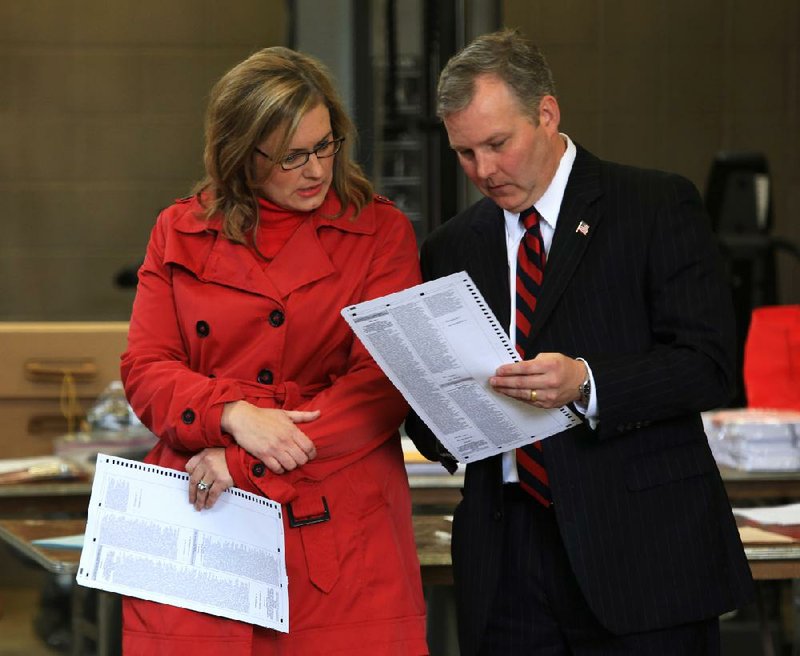 FILE - U. S. Rep. Tim Griffin (right) and his wife, Elizabeth, look at a ballot while waiting to vote the morning of Nov. 6, 2012 in Little Rock. 