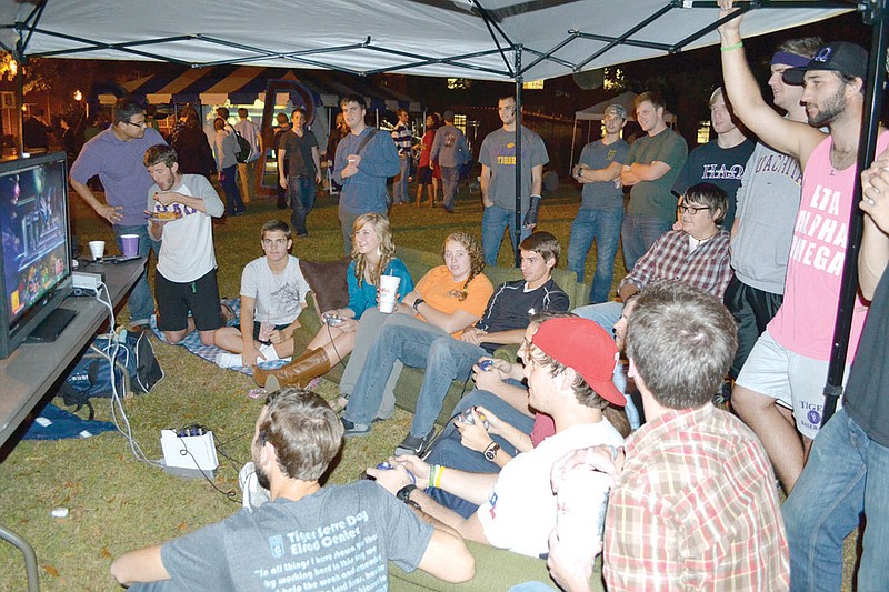 Members of the Ouachita Baptist University junior class play video games to help stay awake and guard the school's tiger statue.