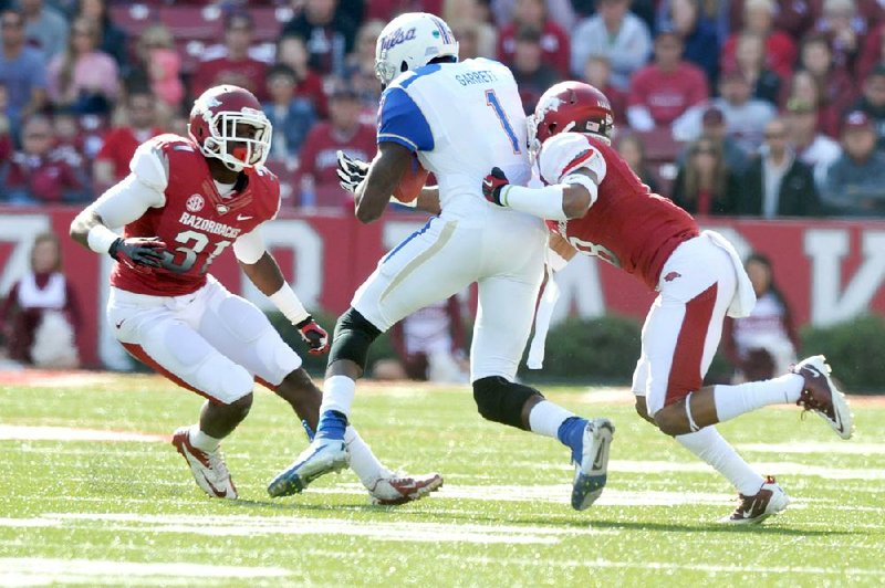  University of Arkansas linebacker A.J. Turner (left) and Tevin Mitchell put the stop on Tulsa receiver Keyarris Garrett during Saturdays homecoming game at Razorback Stadium.