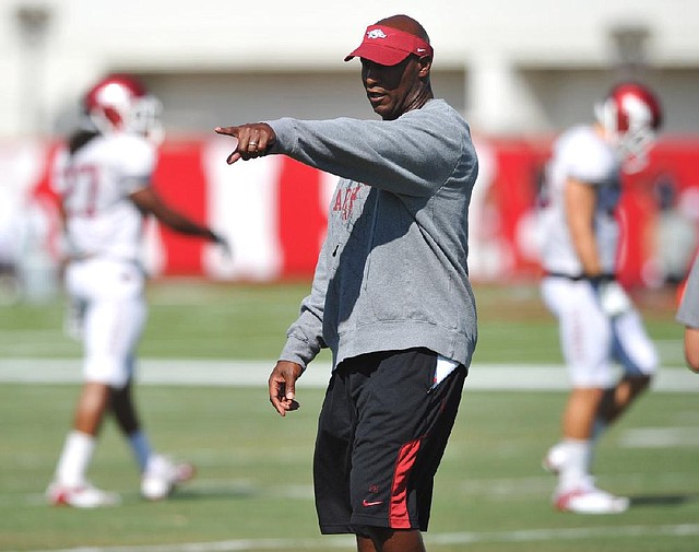 University of Arkansas coach Paul Haynes works with the defense during practice Tuesday afternoon in Fayetteville.