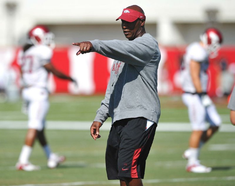 University of Arkansas coach Paul Haynes works with the defense during practice Tuesday afternoon in Fayetteville.