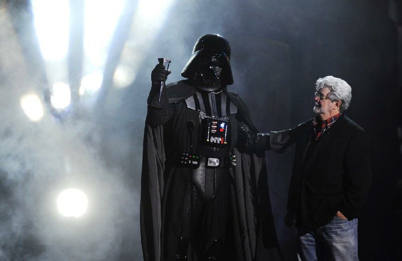 FILE - In this Oct. 15, 2011 file photo, "Darth Vader" accepts the Ultimate Villain award from "Star Wars" creator George Lucas during the 2011 Scream Awards, in Los Angeles. A decade after George Lucas said "Star Wars" was finished on the big screen, a new trilogy is destined for theaters after The Walt Disney Co. announced Tuesday, Oct. 30, 2012, that it was buying Lucasfilm Ltd. for $4.05 billion.  (AP Photo/Chris Pizzello, File)