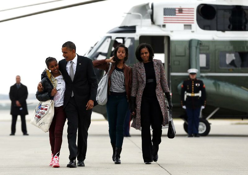 The Obamas and their daughters Sasha (left) and Malia head from Marine One to Air Force One on Wednesday in Chicago. 