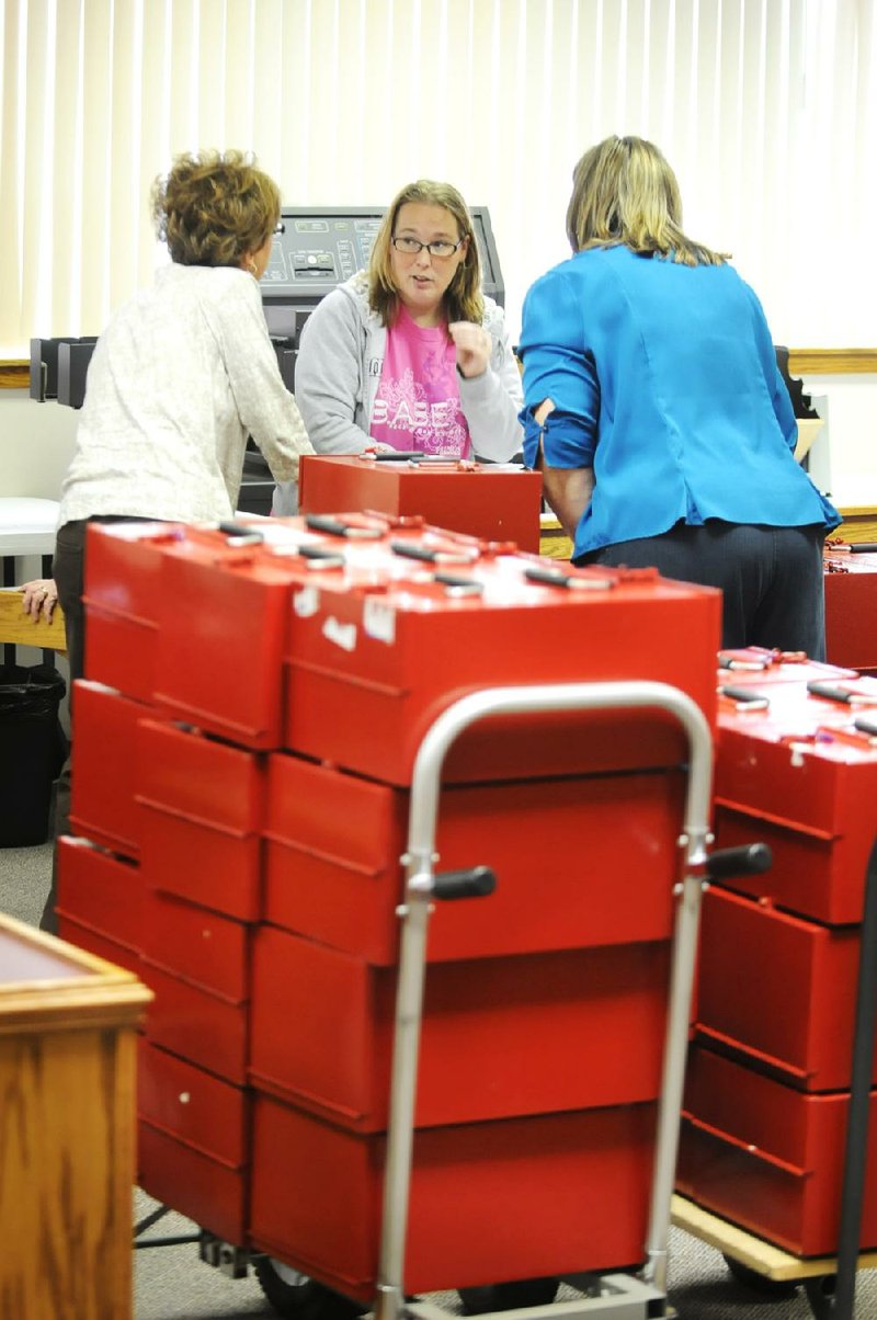 Kim Dennison (center) of the Benton County Election Commission, talks to co-worker Sharon Rose (left) and Lynn Hodge with the Washington County Election Commission about how to process paper ballots moved from Benton County to the Washington County Courthouse so they could be counted. 