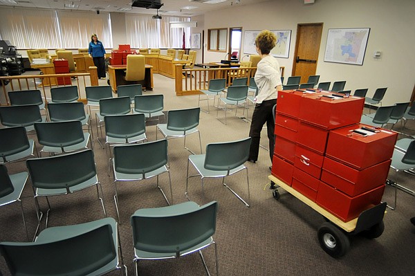 Sharon Rose with the Benton County Election Commission pulls a cart Thursday of Benton County paper ballots into Washington County’s Quorum Court Room where Lynn Hodge, Washington County Election Commission worker, waits to help. After testing several machines they found a Washington County machine that could count the paper ballots the Benton County machines could not. 