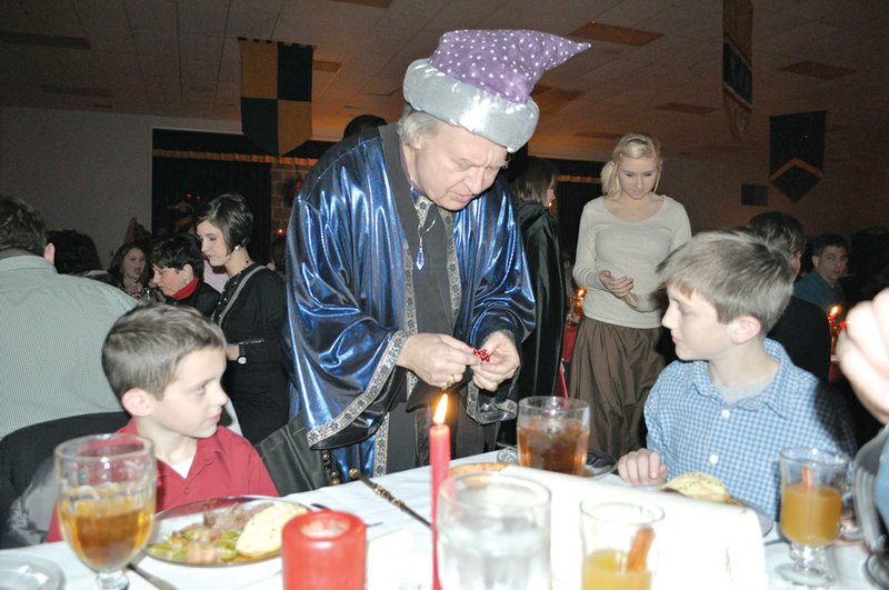 Magician Dan Hecke, center, entertains at a table during last year’s Ye Olde Christmasse Madrigal Feaste. Southside Batesville High School is getting ready for the 18th annual event, to be held Dec. 14 and 15.