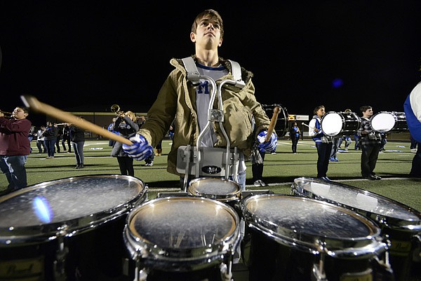 Nathan Aronowitz, 17, Rogers High senior, plays the Mountie fight song on the tenor drums Oct. 26 before the start of the football game against the Siloam Springs in Rogers. 