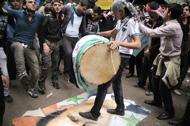 Young Syrians demonstrate Friday in Aleppo, dancing and stomping on a likeness of Syrian President Bashar Assad. 