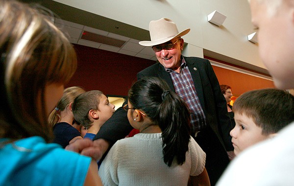 Benton County Sheriff Keith Ferguson greets students from Sugar Creek Elementary School on Friday before a retirement ceremony inside the National Guard Armory in Bentonville. The ceremony was held for Sheriff’s Office officials Ferguson, Col. Don Townsend, Maj. Gene Drake and Capt. Mike Sydoriak. 