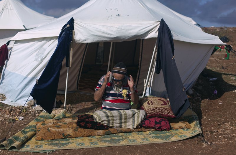 A Syrian elderly disabled man who fled from the violence in his village, prays in front of his tent at a displaced camp, in the Syrian village of Atma, near the Turkish border with Syria. Saturday, Nov. 10, 2012. 