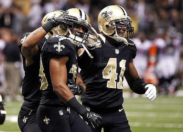 New Orleans Saints cornerback Jabari Greer (33, center) is congratulated by teammates after breaking up a fourth-down pass to end the Atlanta Falcons’ hopes of improving to 9-0. The Saints won 31-27. 