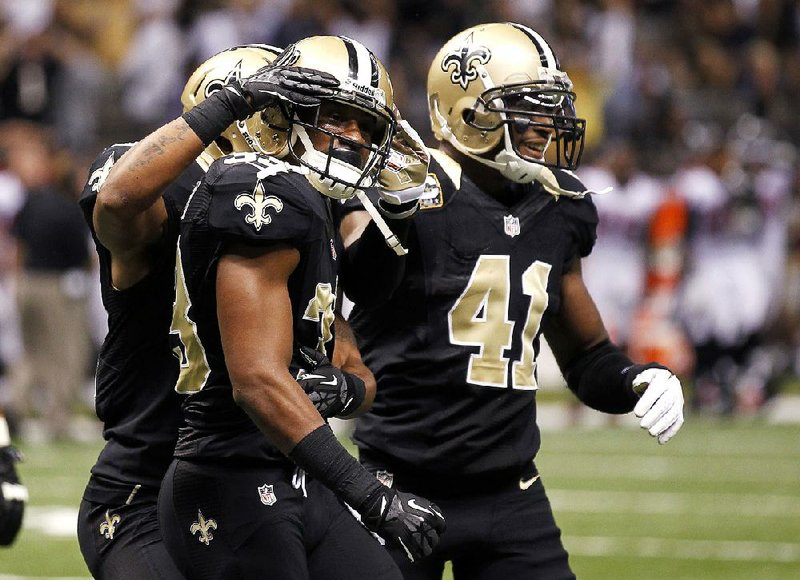 New Orleans Saints cornerback Jabari Greer (33, center) is congratulated by teammates after breaking up a fourth-down pass to end the Atlanta Falcons’ hopes of improving to 9-0. The Saints won 31-27. 