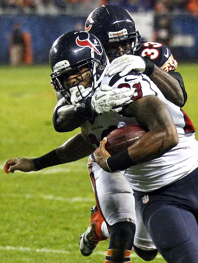 Houston running back Arian Foster is tackled by Chicago cornerback Charles Tillman on Sunday night in Chicago. 