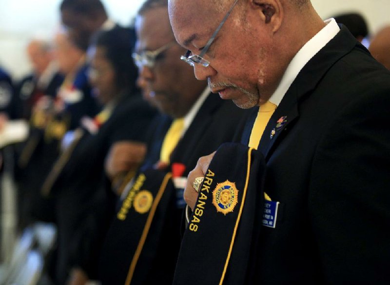 R.D. Kinsey (right) and John Sanders of American Legion Post 74 in North Little Rock bow their heads during the benediction Sunday at the Veterans Day ceremony at the state Capitol. 
