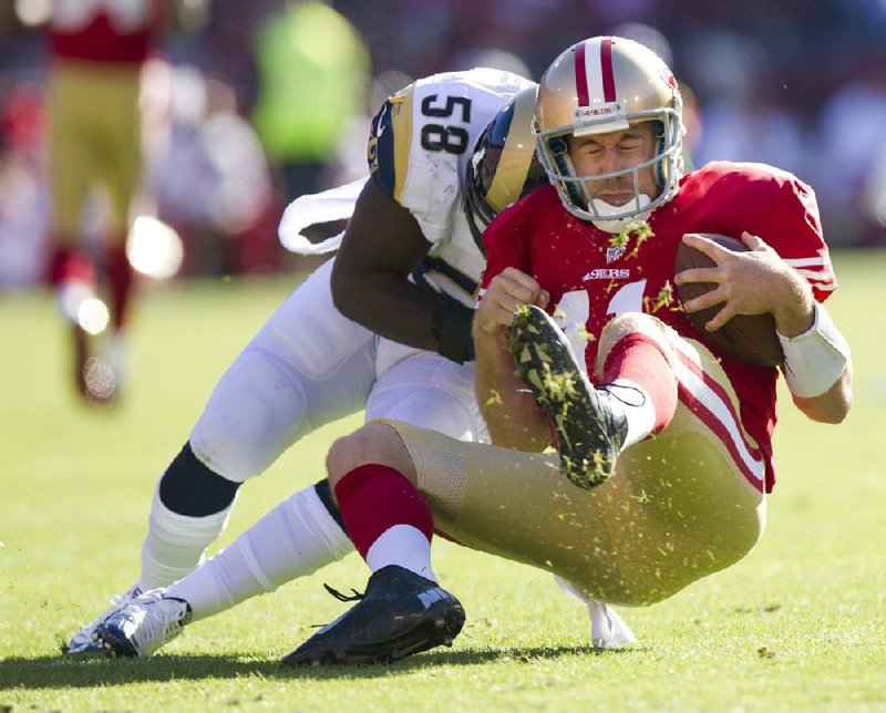 San Francisco 49ers quarterback Alex Smith (11) is tackled by St. Louis Rams linebacker Jo-Lonn Dunbar during the first quarter of Sunday’s game in San Francisco. Smith suffered a concussion on the play. 