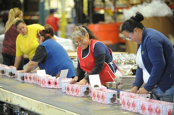Workers at the Hanna’s Candles factory in Fayetteville last week prepare containers of potpourri to be shipped to Sam’s Club. 