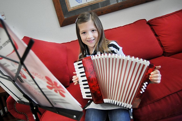 AnnieBeth Mabry, a third-grader at Turnbow Elementary School, holds on Thursday the accordion she is learning to play. She was inspired to pick up the instrument after hearing a guest musician play at her school. AnnieBeth recently played for the Springdale School Board. 
