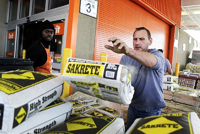 A Home Depot customer tosses a bag of concrete mix onto his truck in Washington, D.C. on Monday. Home Depot reported $947 million in third-quarter net income on Tuesday. 