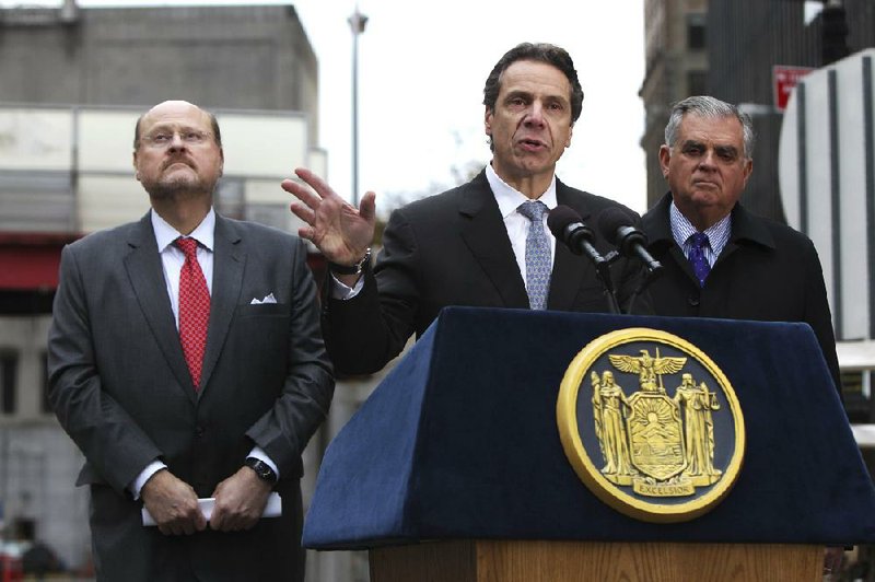 New York Gov. Andrew Cuomo (center) addresses a news conference Tuesday, flanked by state Metropolitan Transportation Authority chief Joseph Lhota (left) and U.S. Secretary of Transportation Ray LaHood in front of the Hugh L. Carey Tunnel, formerly the Brooklyn-Battery Tunnel, in New York. Cuomo announced that the tunnel, which was closed from damage caused by superstorm Sandy, was being opened to limited traffic on Tuesday. 