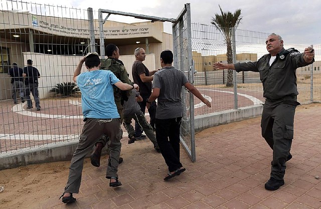 Israeli soldiers and civilians enter a shelter Wednesday in the Neva settlement, near the Israel-Egypt border, as a siren sounds signaling an attack from the nearby Gaza Strip. 