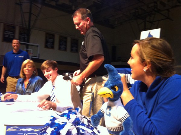 Darian Harris, second from left, a Shiloh Christian senior basketball player, signed a national letter of intent with Creighton University on Wednesday. Also on hand for the signing were his mother, Connie Harris, far left, his father Scott Harris, standing, and sister Chantelle Harris. In the background is Saints coach Brent Hester. 