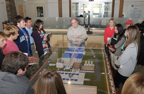 Larry Lloyd, chief operations officer for the Beaver Water District, talks to Springdale Har-Ber High School students about the importance of chlorine treatment in drinking water Wednesday over a scale model of the drinking water treatment facility at Beaver Water District’s administrative office located at 301 N. Primrose Road in Lowell. Seventy Advanced Placement Environmental Science students from Har-Ber and Springdale High School visited the facility as an educational field trip to learn about what the Beaver Water District does and how it affects the surrounding environment. 