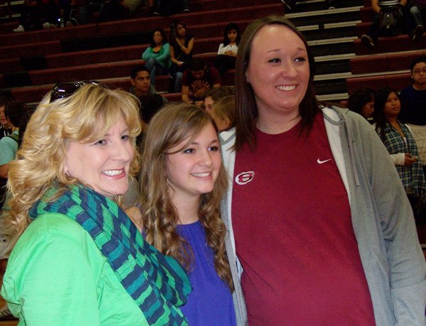 Anna Holcomb, center, a Springdale High volleyball player, stands with Springdale volunteer assistant Karen Morris, right, and coach Amanda Williford on Wednesday after signing a letter of intent to play volleyball at Ouachita Baptist. 