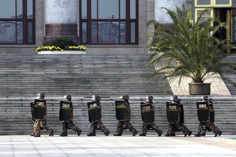 Chinese soldiers march Thursday outside the Great Hall of the People, where China’s new leaders met the press the same day in Beijing. 