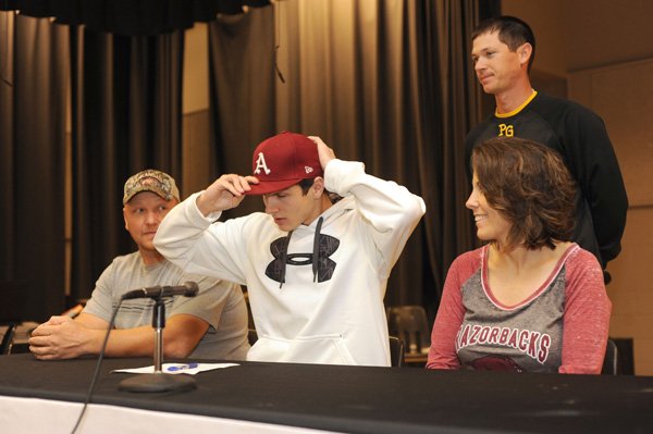 Aaron Kincaid, center, Prairie Grove senior, signs Thursday to play baseball for the University of Arkansas while his father, Chris, left; mother, Bonnie; and Prairie Grove coach Mitch Cameron watch during a ceremony at the school. Kincaid will join fellow Tiger Jalen Beeks on the Razorback roster. 