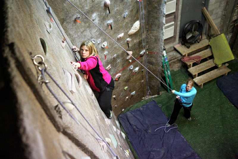 Kim Smith works her way up a climbing wall at the Zion Climbing Center while Heather Jones belays her. The center offers several 17-foot top-rope climbing walls and two bouldering rooms.