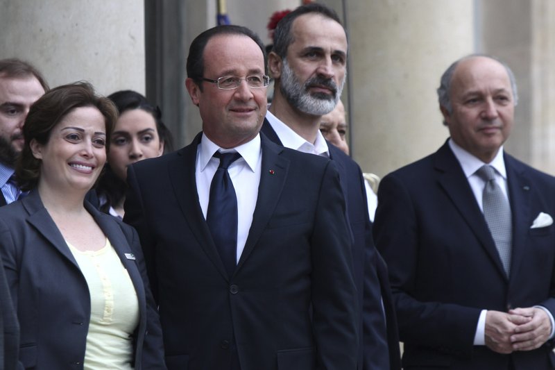 French President Francois Hollande, second from left, head of the new Syrian National Coalition for Opposition and Revolutionary Forces Mouaz al-Khatib, second from right, Syrian opposition member Suheir Atassi, left, and French Foreign Minister Laurent Fabius, right, pose for photos, prior to a meeting, at the Elysee Palace, in Paris, Saturday, Nov. 17, 2012. France has taken a leading role among Western countries in supporting Syria's rebels. On Tuesday, it became the first Western nation to formally recognize Syria's newly formed opposition coalition as the sole legitimate representative of the Syrian people.