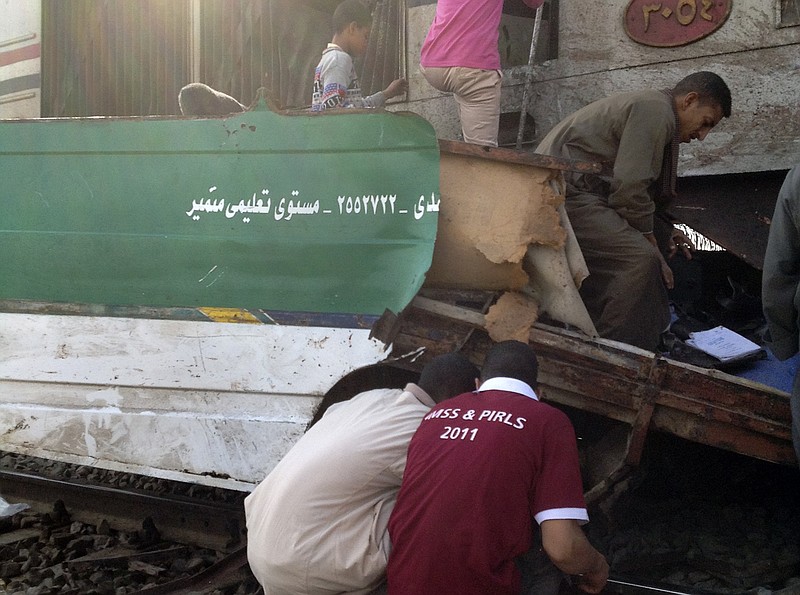 Egyptians inspect the wreckage after a speeding train crashed into a bus carrying children to their kindergarten in southern Egypt on Saturday, killing at least 47, officials said, near Assiut, in southern Egypt, Saturday, Nov. 17, 2012. The bus was carrying more than 50 children between 4 and 6 years old when it was hit near al-Mandara village in Manfaloot district in the province of Assiut, a security official said, adding that it appears that the railroad crossing was not closed as the train sped toward it.