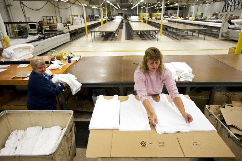 Employees at FesslerUSA in Orwigsburg, Pa., count and stack T-shirt components last month. The Federal Reserve said Friday that disruptions from superstorm Sandy were behind a 0.9 percent decline in factory output in October from September. 