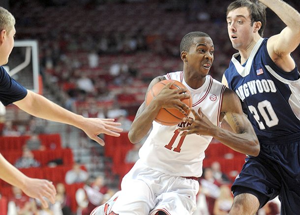 NWA Media/ANDY SHUPE -- Arkansas sophomore guard BJ Young, center, drives to the lane past Longwood freshman forward Karl Ziegler (20) Sunday, Nov. 18, 2012, during the first half of play in Bud Walton Arena.