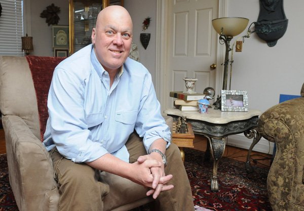 Bud Planchon, a retired fire captain, sits in his home Tuesday in Fayetteville. Planchon retired from the Springdale Fire Department in August 2011 after more than 24 years with the department. 