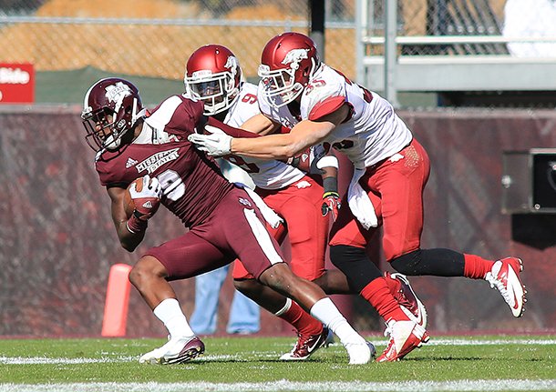 Arkansas Democrat-Gazette/RICK MCFARLAND --11/17/12-- Arkansas's Will Hines (9) and Ross Rasner (35) hang onto Mississippi State's Chris Smith (8) after he caught a pass in their game at Davis Wade Stadium in Starkville, Miss.