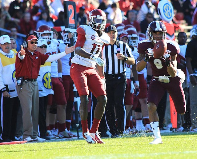 Arkansas Coach John L. Smith (left) reacts as Mississippi State’s Darius Slay (9) intercepts a fourth-quarter pass from Tyler Wilson intended for Cobi Hamilton (11). Slay’s 15-yard return was nullified by a Mississippi State personal foul, but Nick Griffin scored on a 60-yard run on the next play, giving the Bulldogs a 45-14 lead. 