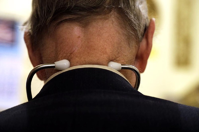 In this Tuesday, Oct. 30, 2012 photo, Dr. Russell Dohner wears a stethoscope around his neck as he tends to patients in his office in Rushville, Ill. (AP/Jeff Roberson)