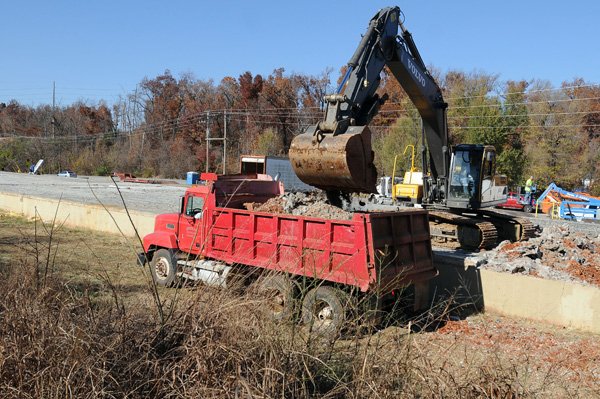 Workers with Dirt Co. haul away the foundation Wednesday of a former warehouse on Johnson Road in Johnson, making way for improvement to the road. The Johnson Road project will connect the road to Greathouse Springs Road near Interstate 540. 