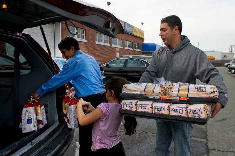 Kamal Moharam and his children Nadine and Kareem load their car with Wonder Bread on Friday at a Hostess Brands Inc. outlet in Sacramento, Calif. The judge overseeing the Hostess bankruptcy asked management and the baker’s union on Monday to try mediation today. 