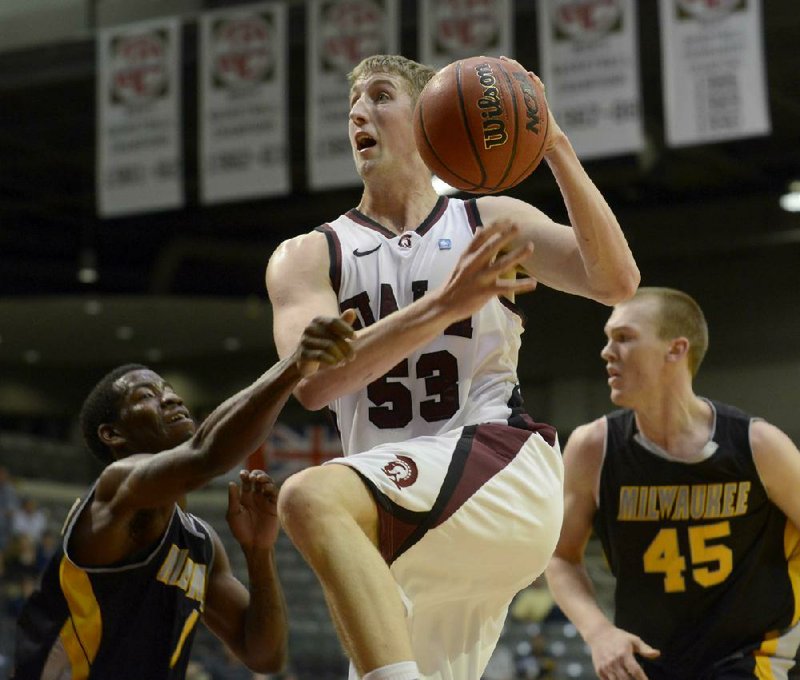 UALR forward Will Neighbour (53) leaps past Wisconsin-Milwaukee’s Jordan Aaron (left) and Christian Wolf during Monday’s game at the Jack Stephens Center in Little Rock. Neighbour finished with 17 points. 