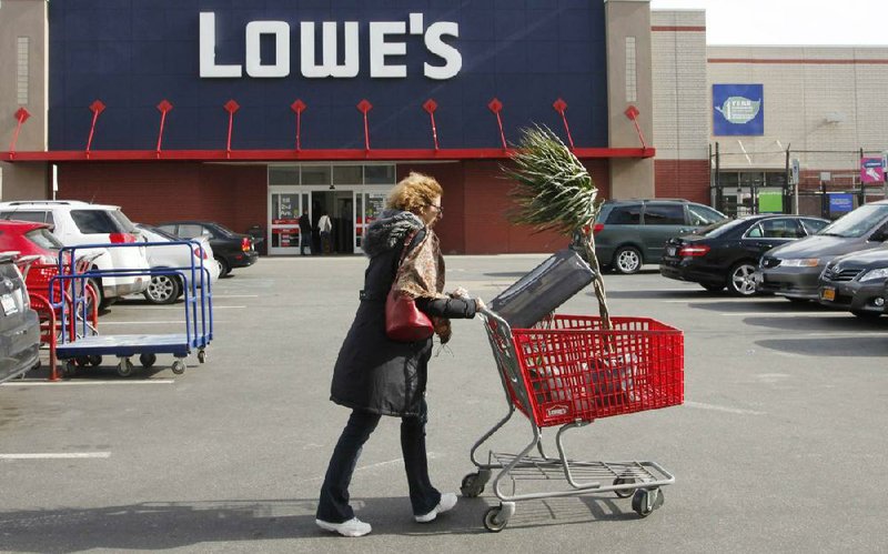 A customer pushes her Lowe’s purchases to her car in New York in this file photo. Lowe’s on Monday reported a third-quarter profit of $396 million. 