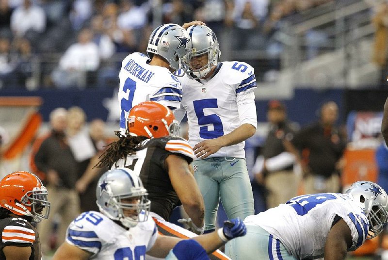 Dallas Cowboys holder Brian Moorman (2) congratulates Dan Bailey (5) after Bailey kicked the game-winning field goal in overtime of Sunday’s game in Arlington, Texas. Bailey made a field goal with 2 seconds remaining in regulation to force overtime. 